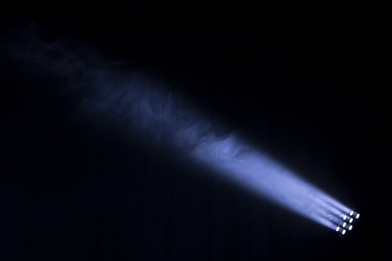 a spotlight shooting a beam into the ark night sky highlighting smoke in the air in rossendale lancashire england, light beams in england sky 4k