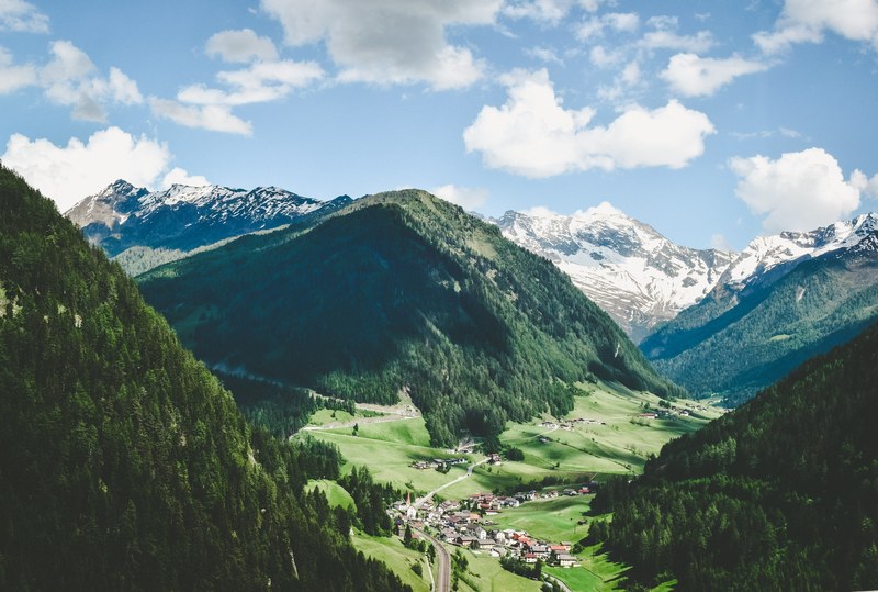 a village in a deep mountain valley on a bright day, picturesque mountain village 4k