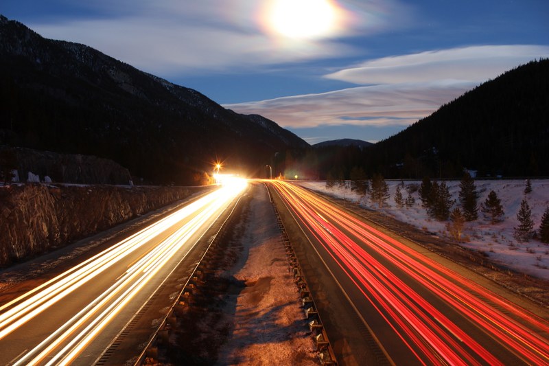 time lapse of a mountain road in colorado showing bright headlights mountains and snow under trees, time lapse mountain road colorado 4k