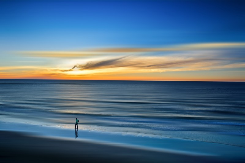 man walking beach in tel aviv yafo with sunset reflecting over ocean, tel aviv yafo beach sunset 4k