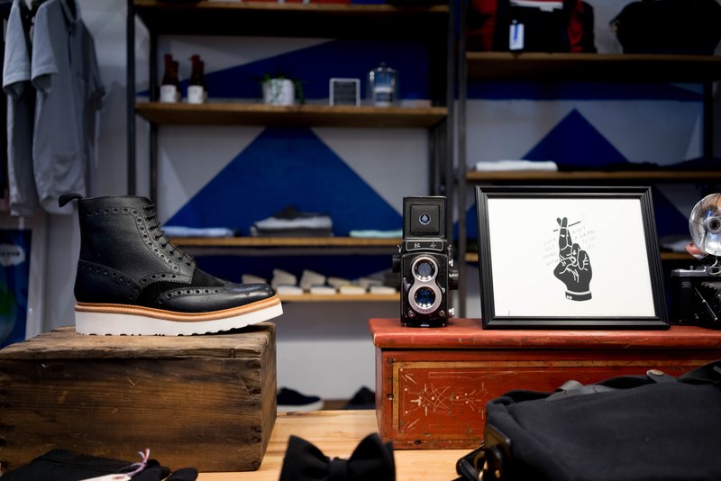 the vintage interior of an apparel store with a poster and a black leather shoe, vintage apparel store interior 4k