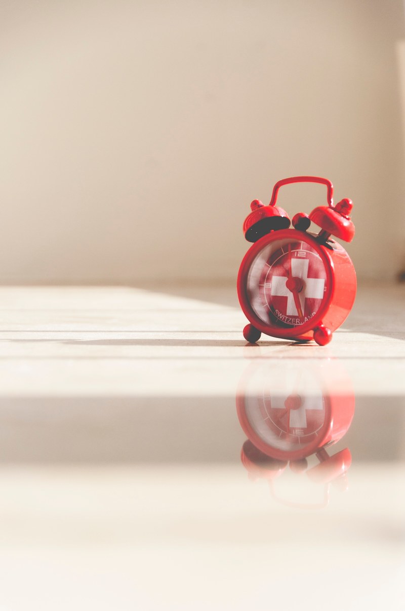 a red vintage alarm clock with the swiss flag, swiss alarm clock 4k