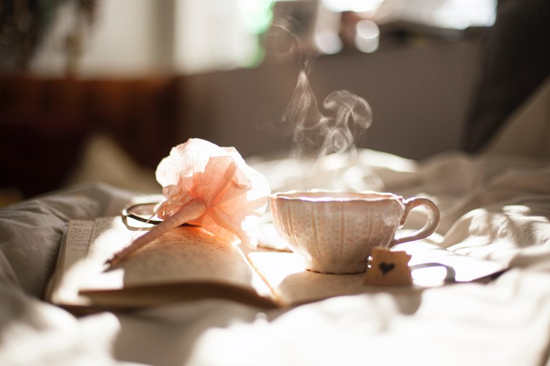 a beautiful ceramic teacup placed on a diary while the tea evaporates as steam, ceramic teacup 4k