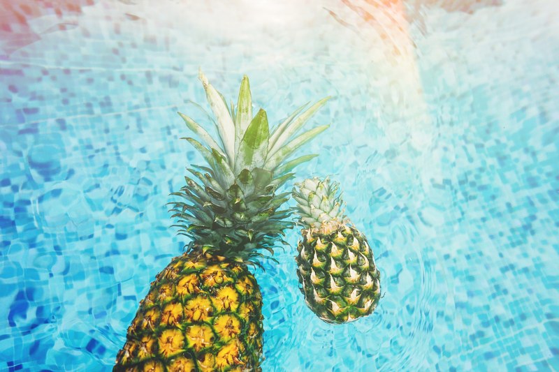fresh pineapples floating in a blue pool, pineapples in the pool 4k
