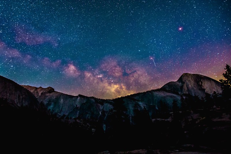 purple hued constellations in the night sky over a mountain ridge, purple night sky 4k