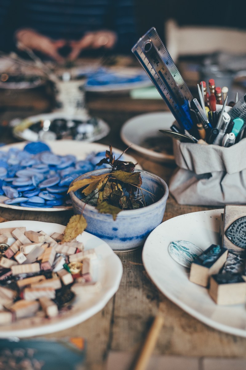 messy art supplies in bowls and plates on wooden table with ruler in pot, making winter 4k