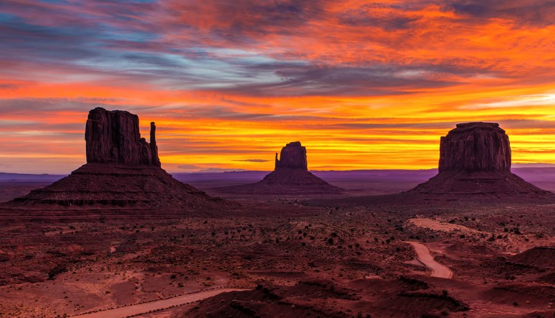 a bright orange and blue sunset covers the rock formations of oljato monument valley, a new day in heaven 4k
