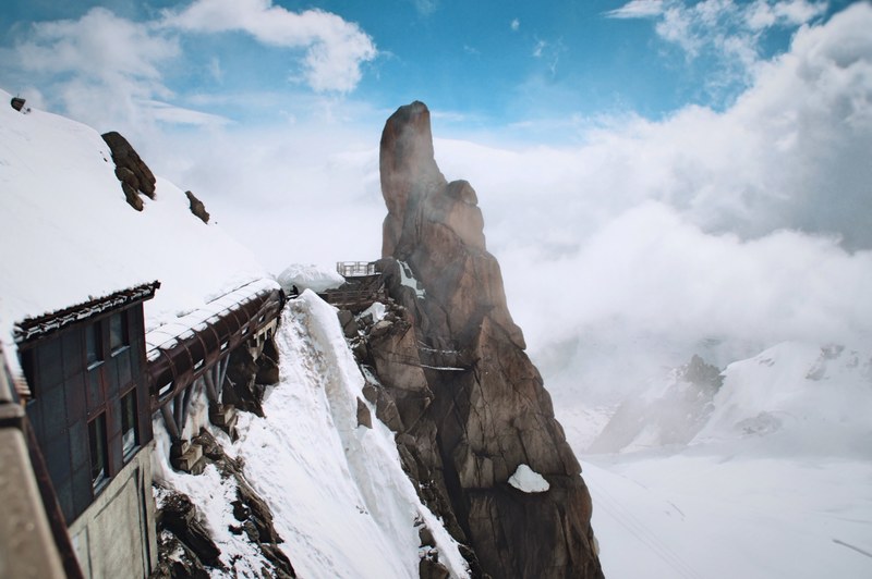 an angular shot of an observation platform on a snowy mountainside in aiguille du midi, observation platform by a rock tower 4k