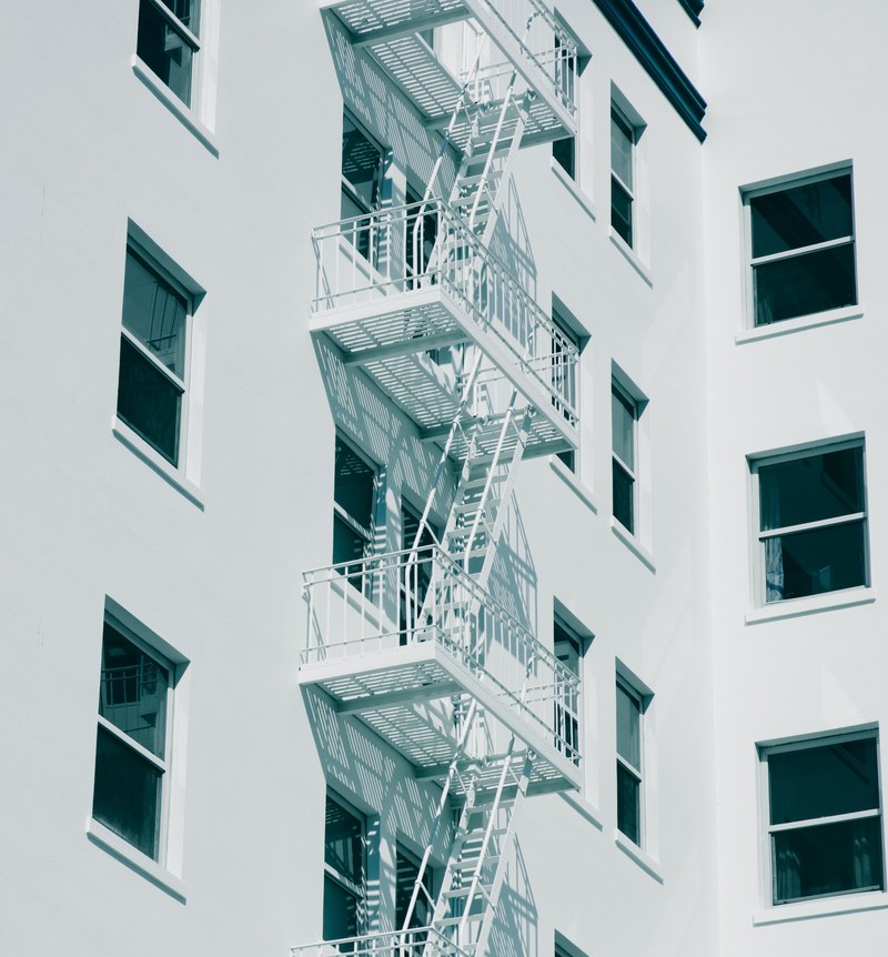 black and white shot of white fire escape staircase and windows on building in berkeley, white berkeley fire escape 4k