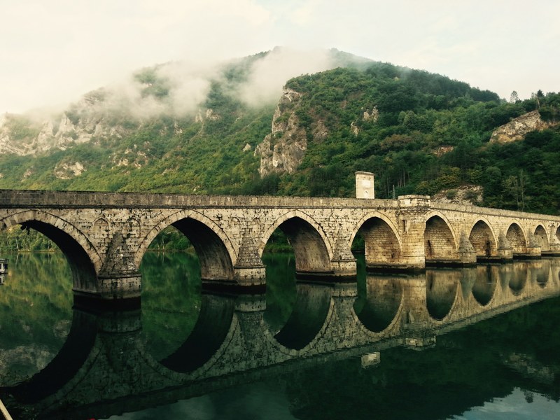 an old aqueduct over a river in viegrad, aqueduct on a river 4k