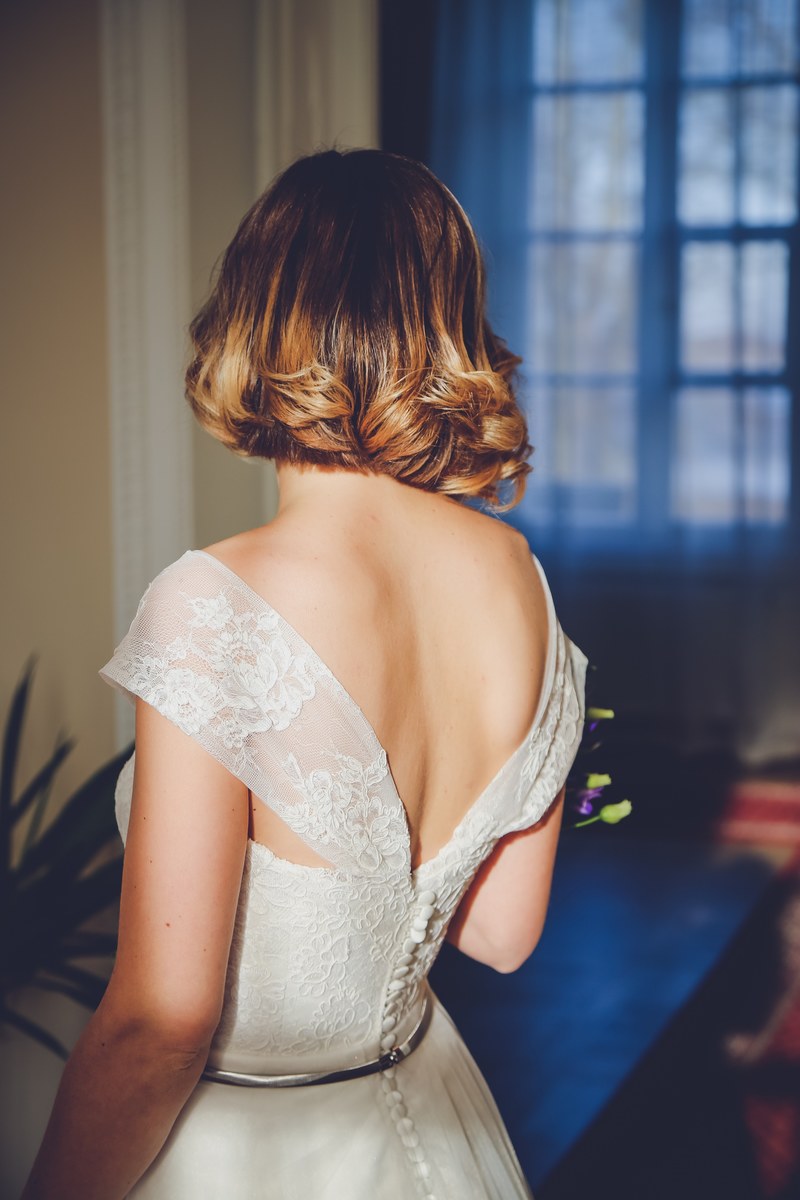 bride from behind looks toward window down hallway, bride looks toward window 4k