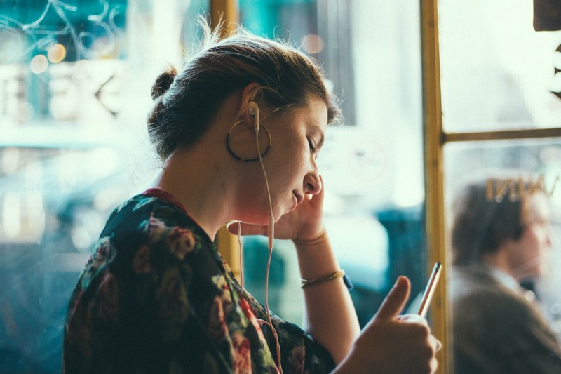tired woman rests her pen while working in a cafe and listening to music, focus music 4k