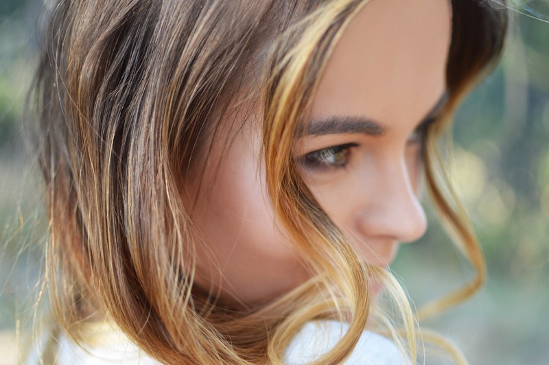 a close up of a womans face with curled hair smiling to the side, close up of womans face 4k