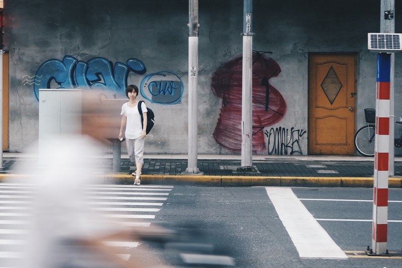 blurry shot of people walking down a sidewalk and crossing the street, pedestrians walking 4k