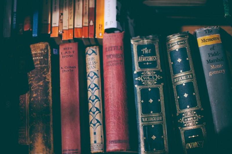 classic old books with hardback arranged on a bookshelf in a library, old books on bookshelf_ 4k