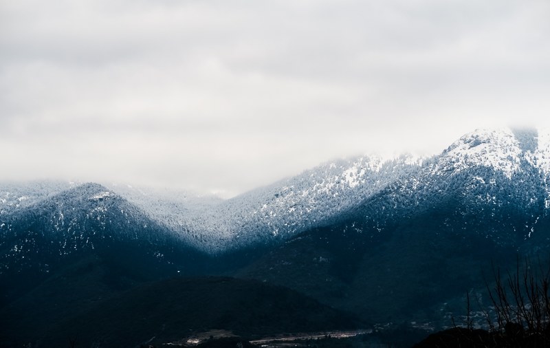a wooded mountain pass in stymfalia under a pale cloudy sky, overcast sky over a mountain pass 4k