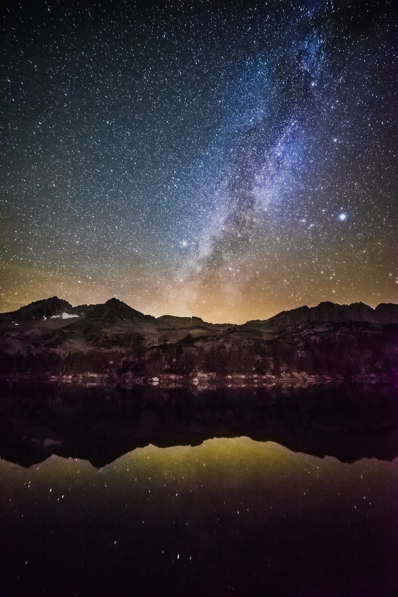 a starry sky with blue clouds above mountains and a lake, _starry sky over mountains 4k
