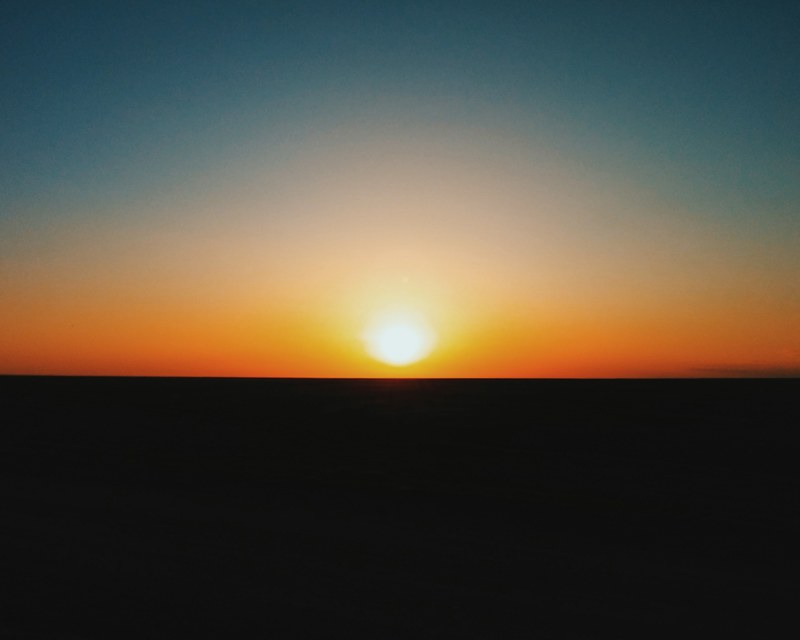 sun rises on the horizon against a colorful sky, colorful sunrise 4k