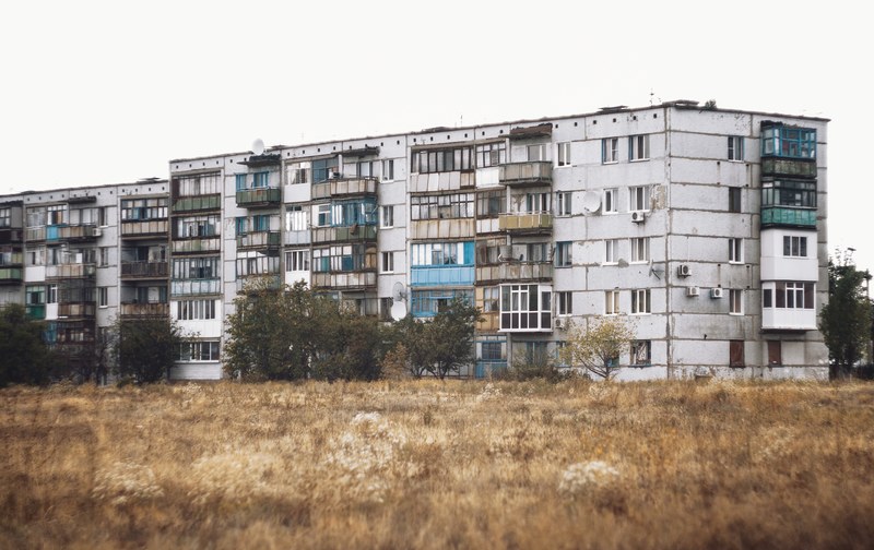 a broken down apartment building with rotting balconies, old decaying building 4k