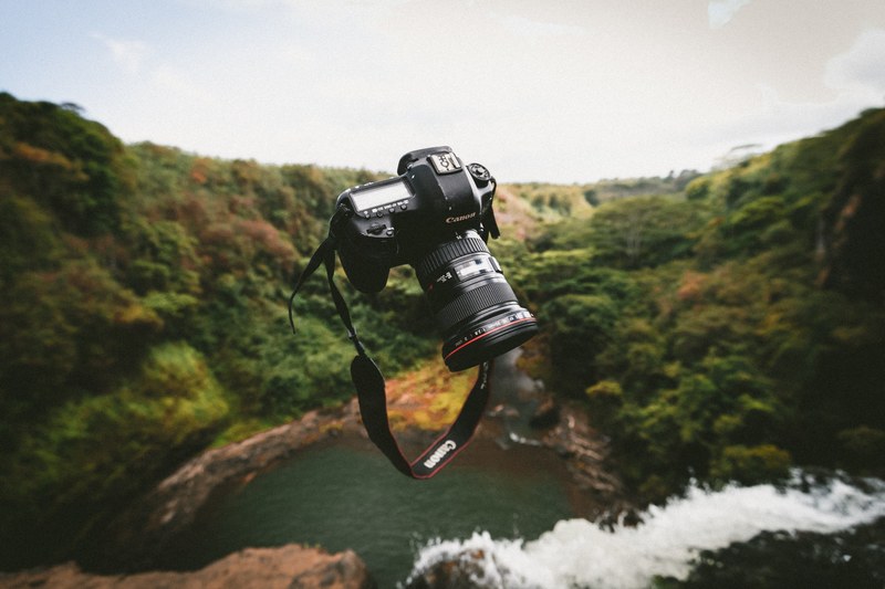 a canon camera is seen hovering over a waterfall in new york texas, _floating canon lens 4k