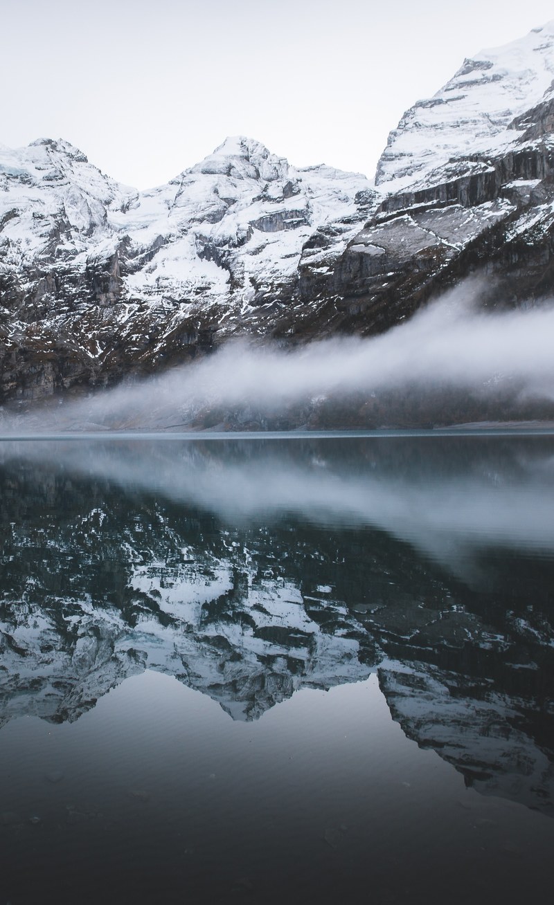 reflections of snowy mountains reflect in calm foggy waters of oeschinen lake, lake oeschinen 4k