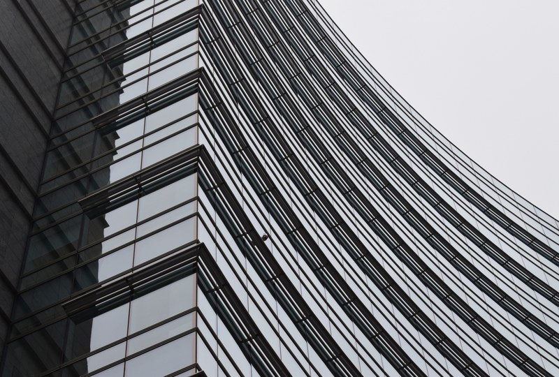 black and white shot of curved building architecture and windows at piazza gae aulenti, piazza gae aulenti milan italy 4k