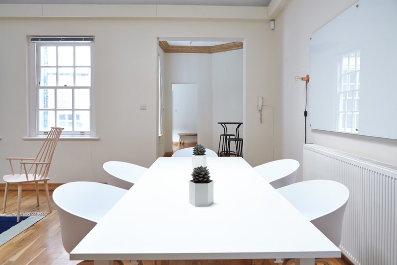 an office space with a white table and a whiteboard on a wall, white office space 4k