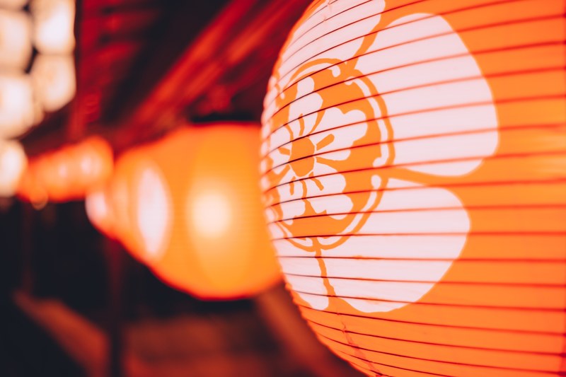 macro of decorative glowing orange paper lantern with floral design in kyoto, orange lantern in kyoto 4k