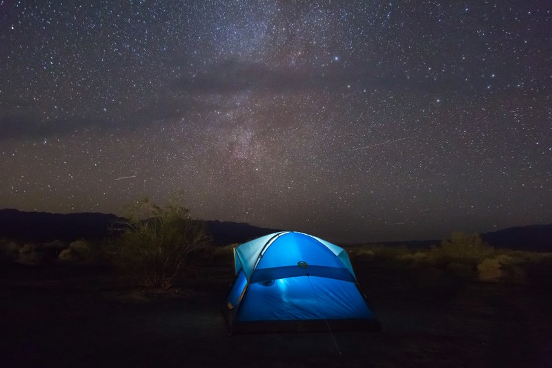 blue tents glows in against a dark starry night sky, amazing stars 4k