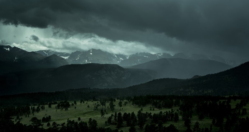 overcast sky over a wooded plain near the mountains in rocky mountain national park, gray sky over mountain forests 4k