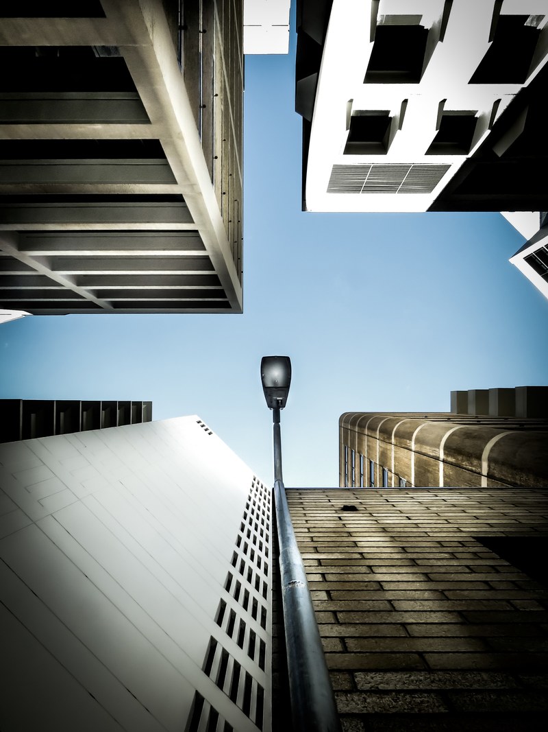 a low angle shot of a lamppost adjacent to a building facade, lamppost on a facade 4k