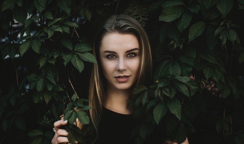 woman standing in a leafy bush and smiling, victoria 4k