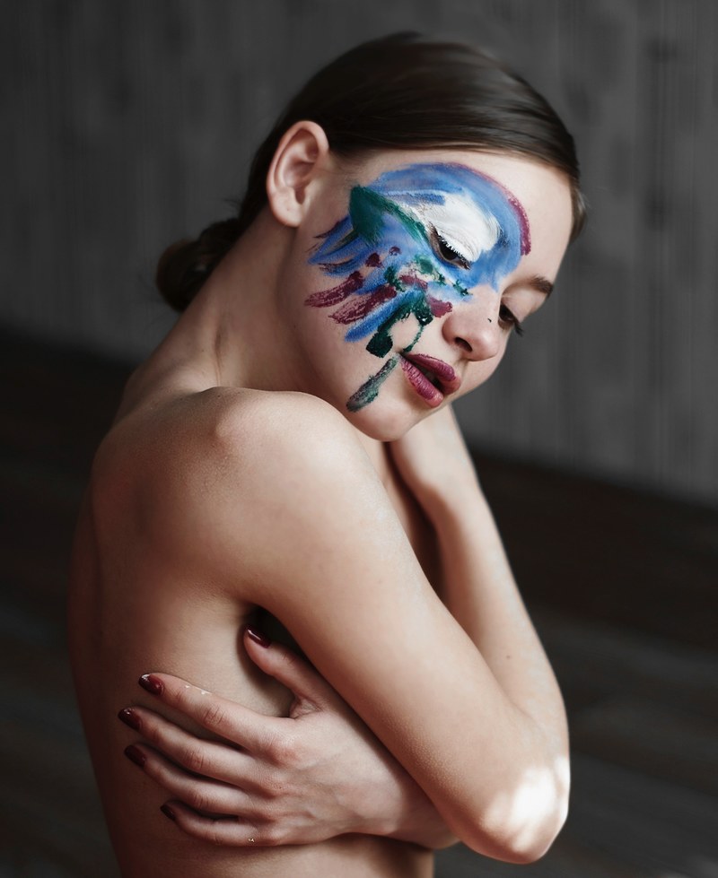 woman posing topless with artistic body pain on her face, artsy face paint 4k
