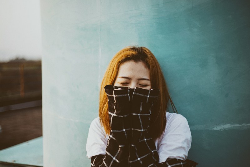 a woman with red hair wearing a flannel shirt in pleiku, sleeves over her face 4k