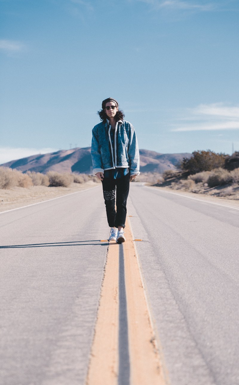 a person stands and walks right in the middle of a road with double lines, samson 4k