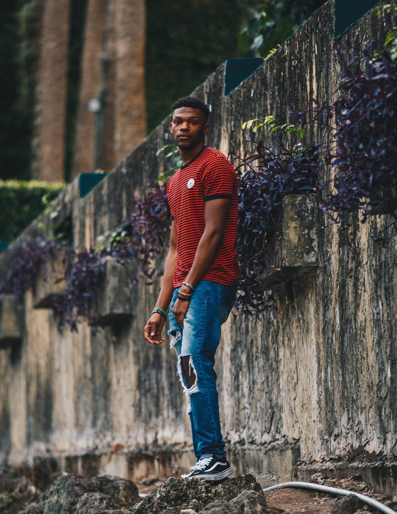 an african american man in ripped jeans and a red striped shirt, _african american posing 4k