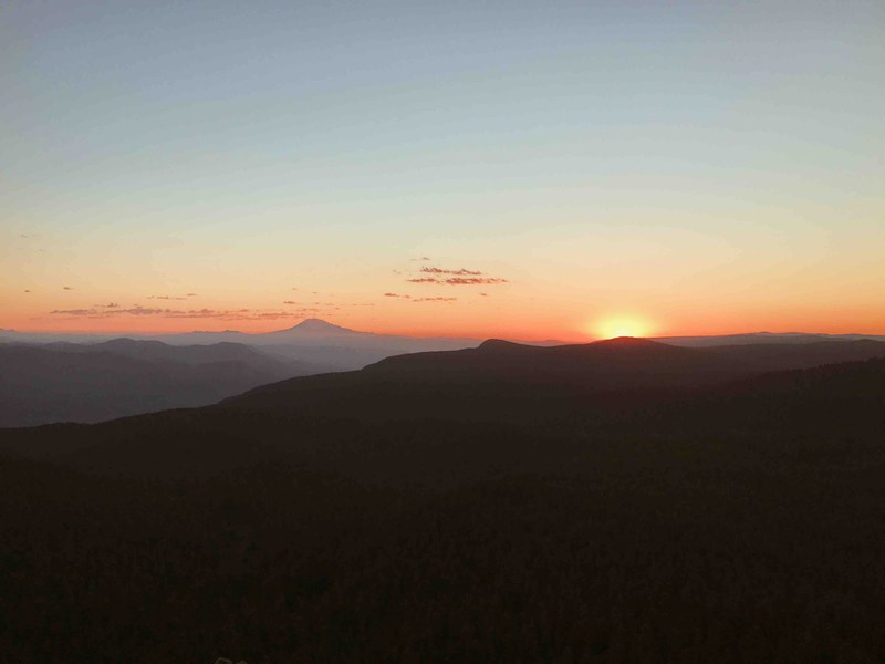 low sunset or sunrise behind hills with an orange and light blue sky, _sunrise at larch mountain 4k