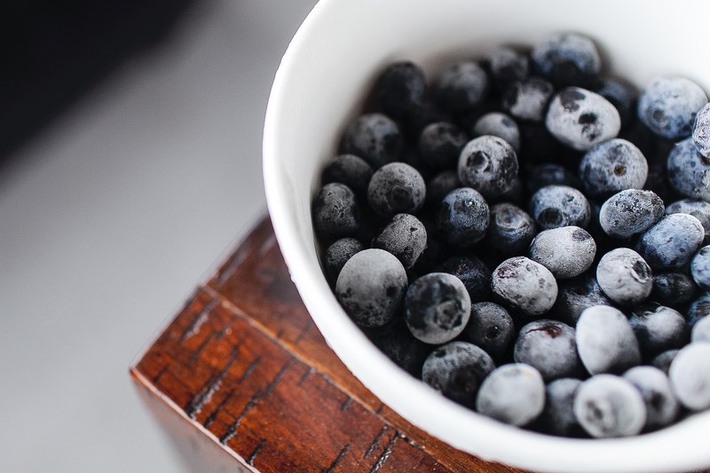close up of frozen blueberries in a white bowl, frozen blueberries 4k