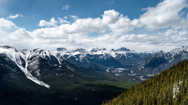 a picturesque green valley surrounded by snow capped mountains, green valley in the white mountains 4k