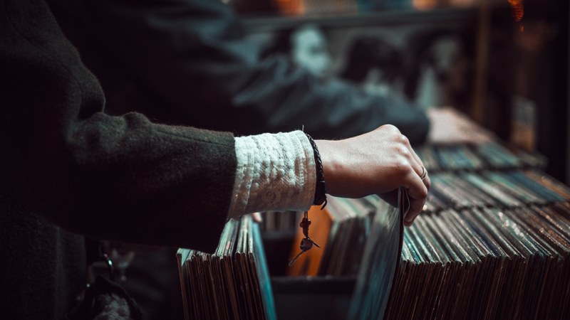 a close up of the hand of a person browsing vinyl records at a store, browsing record store shelves 4k