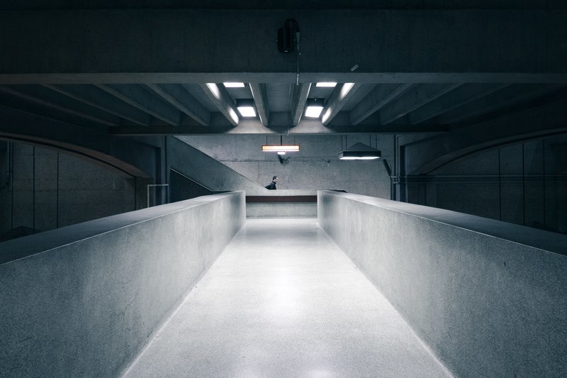black and white interior of building with concrete architecture and a person in the background, black white concrete interior 4k
