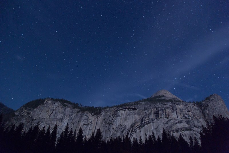 a granite cliff in yosemite under a starry night sky, yosemite cliff under stars 4k