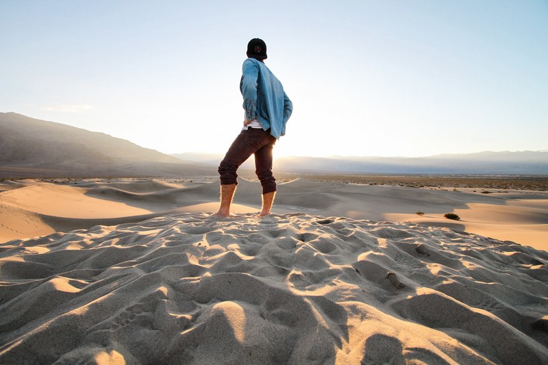 hiker stands proudly in the desert sand of death valley national park, standing proud 4k