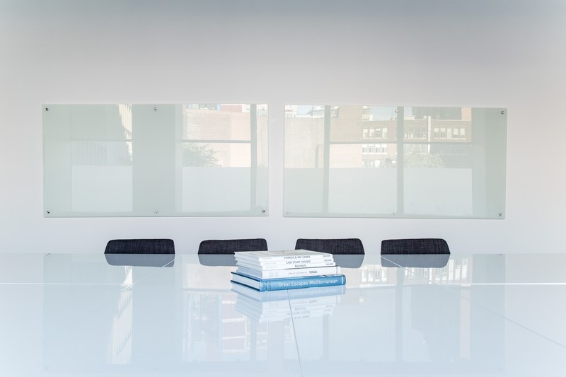a stack of books on a glossy table in an office meeting space, books in a meeting space 4k