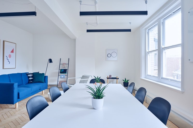 a minimalist interior with a long white table and a blue sofa, white minimal interior 4k