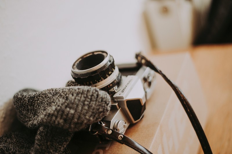 a knit scarf and a vintage camera on a cardboard box, knit scarf and camera 4k