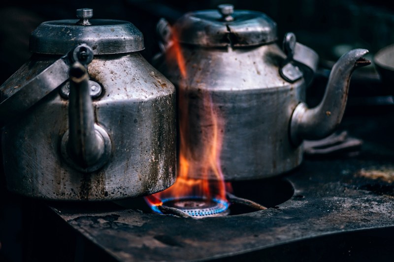 rustic metal tea pots on an open flame, boiling tea kettles 4k