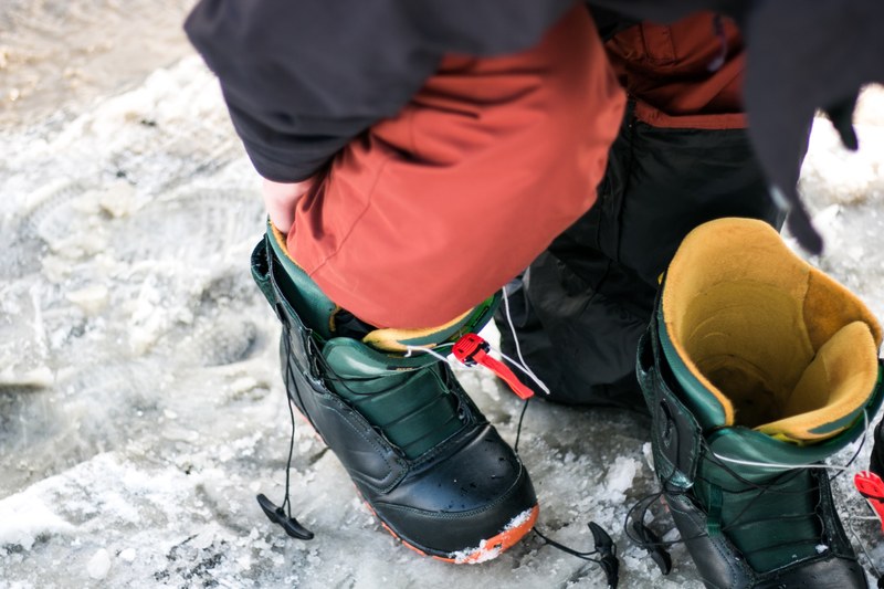 hiker puts on hiking boots and gear before a trek through the snow, hiking boots 4k