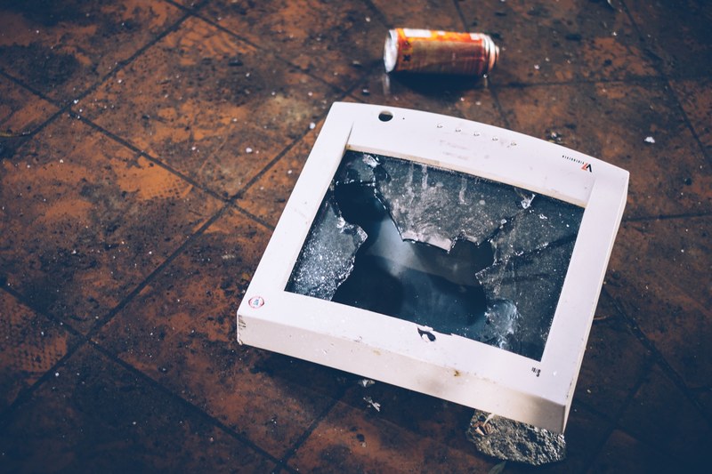 a smashed old piece of display technology on a dirty floor, broken display glass 4k