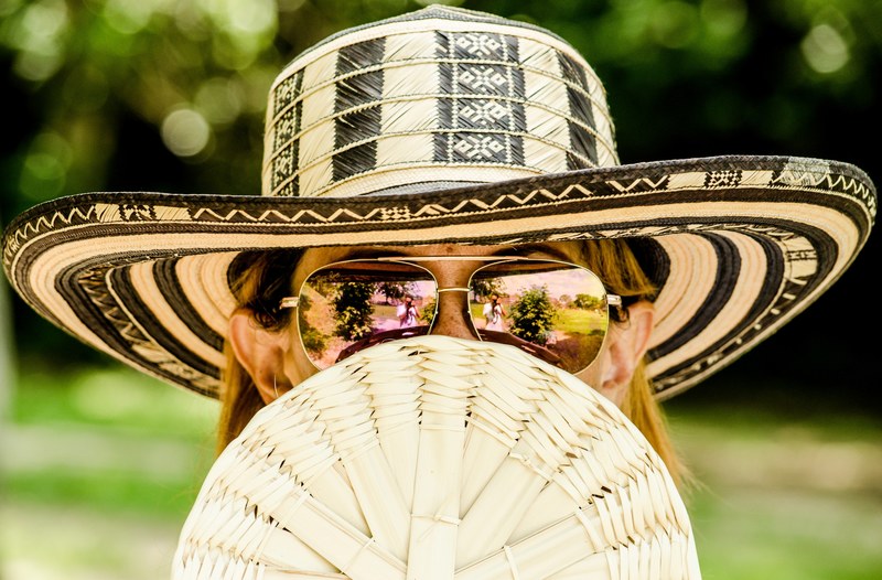 a blonde woman wearing a sun hat with sunglasses while holding a fan, woman holding fan 4k
